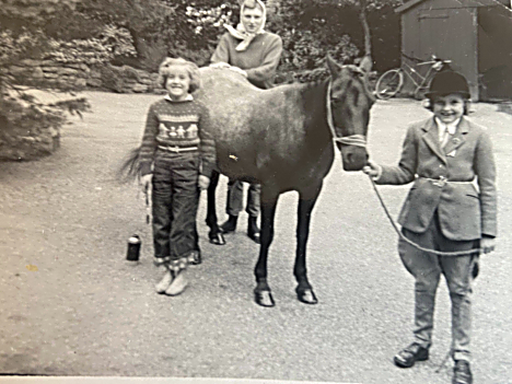 Children with a pony, one dressed for a show with number tied on